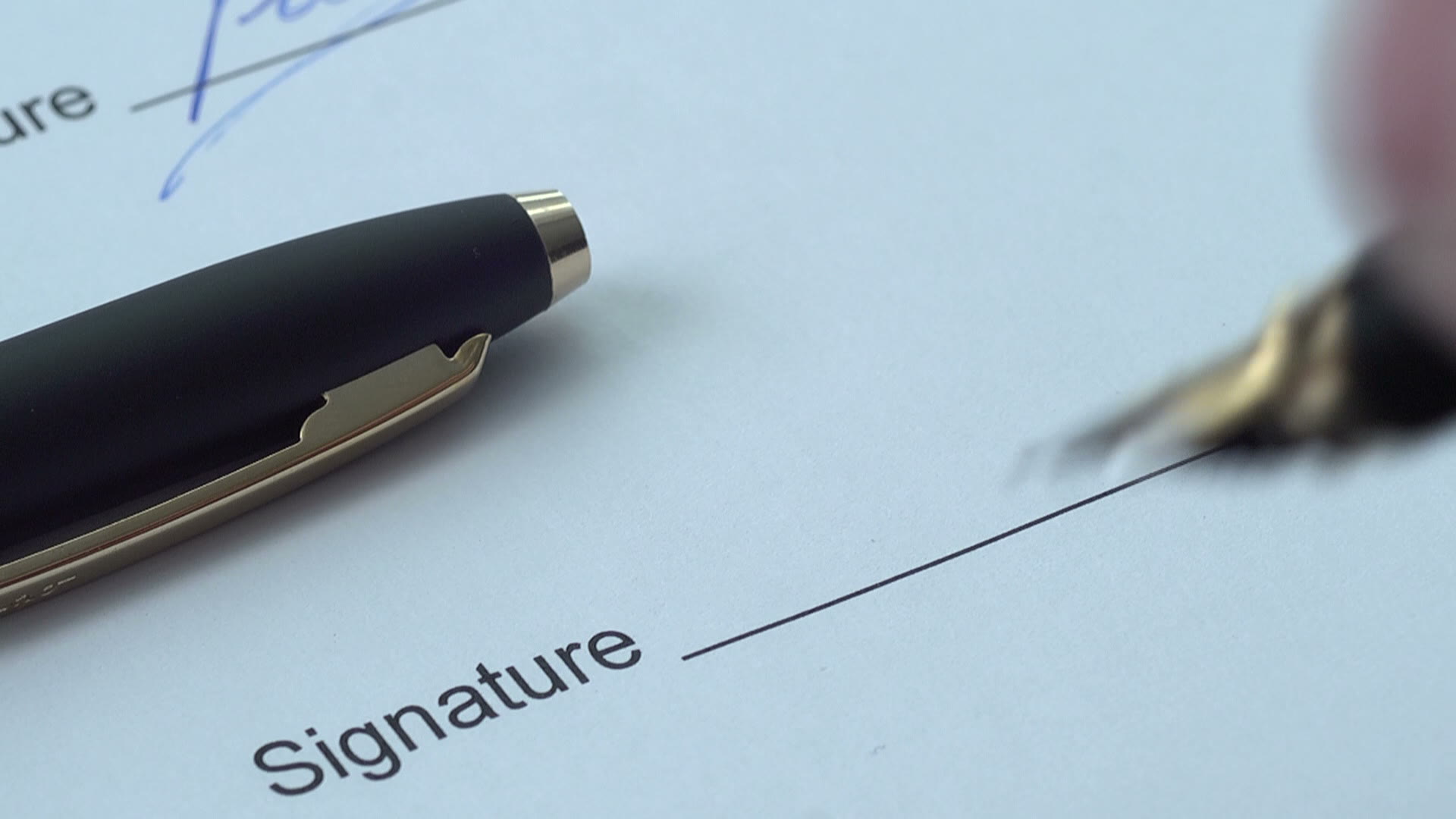 Close-up of a contract being signed with a fountain pen